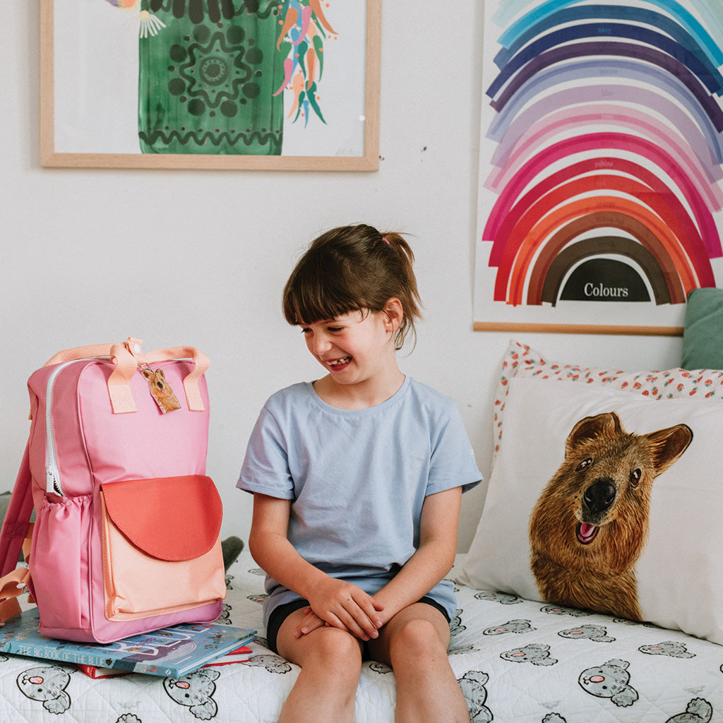 school girl with pink school bag and australian quokka key chain and quokka pillowcase in colourful styled kids room