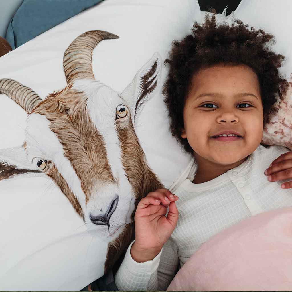 goat pillowcase with girl smiling in bed