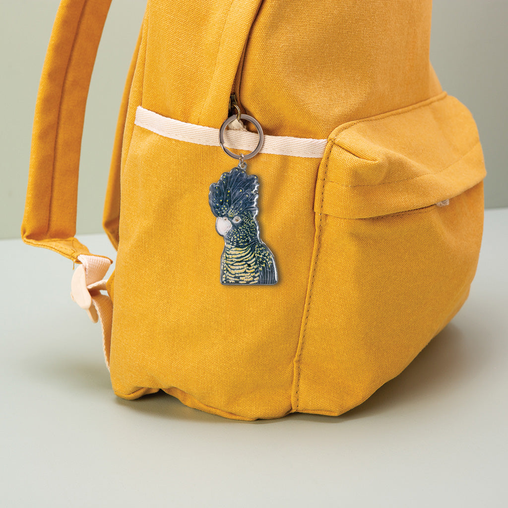 red tailed black cockatoo australian bird  watercolour artwork enamel keychain on yellow canvas backpack