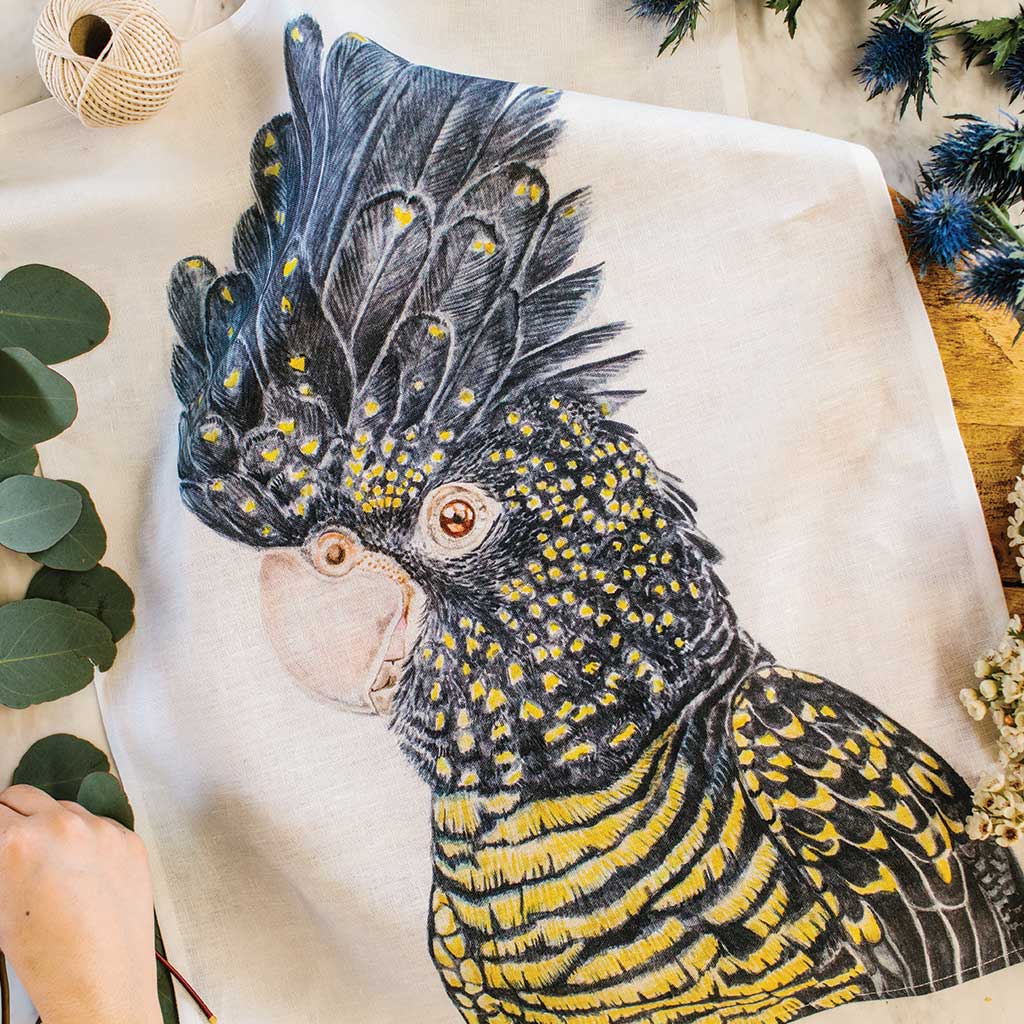 white linen tea towel with red-tailed black cockatoo watercolour artwork